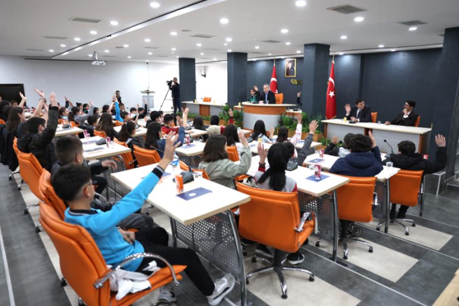 Le conseil municipal, composé d'étudiants, se réunit pour examiner l'ordre du jour du 105e anniversaire.